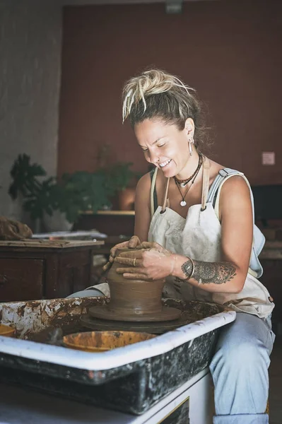 Creativity is the one thing I cant live without. a young woman working with clay in a pottery studio