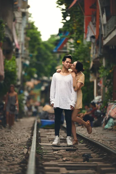 她的吻使我的心发笑 一对年轻夫妇在越南街头的铁轨上共度一段浪漫时光 — 图库照片
