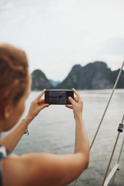 Güzel Vietnam 'dan fotoğraflar. Genç bir kadın akıllı telefonuyla Vietnam 'da bir nehrin fotoğraflarını çekiyor.