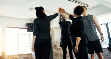 Her şey o fitness hakkında. Spor salonunda egzersiz yapmadan önce bir araya toplanmış neşeli genç bir grup insan.