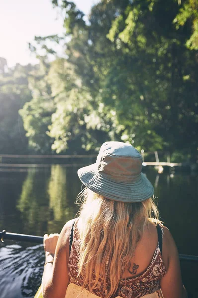 この場所はあなたに平和と静けさのシュールな感覚を与えます 湖でカヤックをしている若い女性が — ストック写真