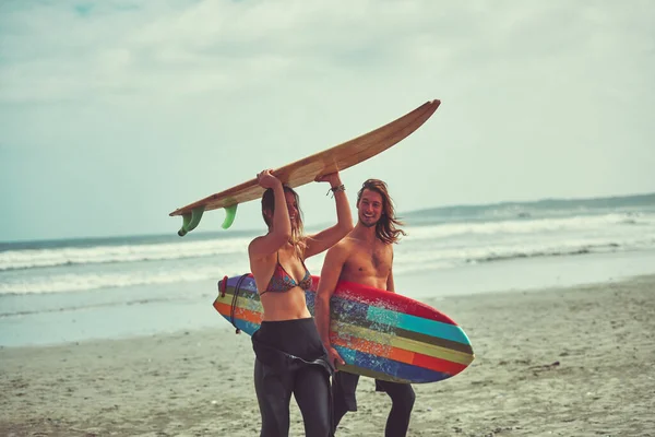 冲浪总是一个好主意 一对带着冲浪板在海滩上散步的年轻夫妇 — 图库照片