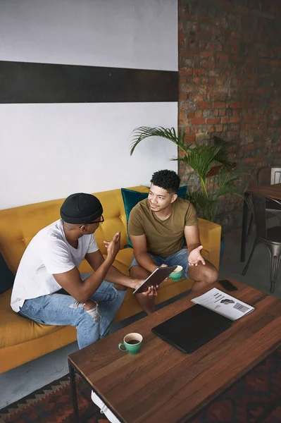 我们需要彻底地计划这一切 两个年轻人一起坐在咖啡店里用数码平板电脑 — 图库照片