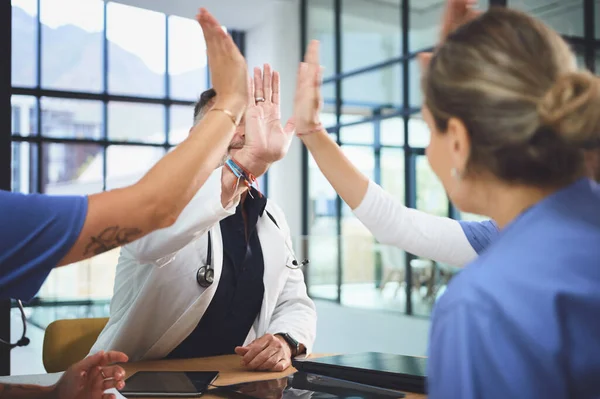 stock image High fiving to good health. a team of doctors giving each other a high five in a hospital