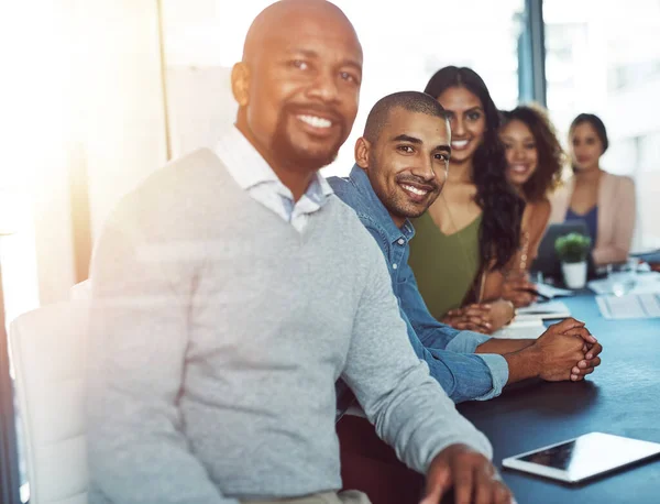 stock image I have the greatest support system. a businessman standing out over the rest of his colleagues in a boardroom