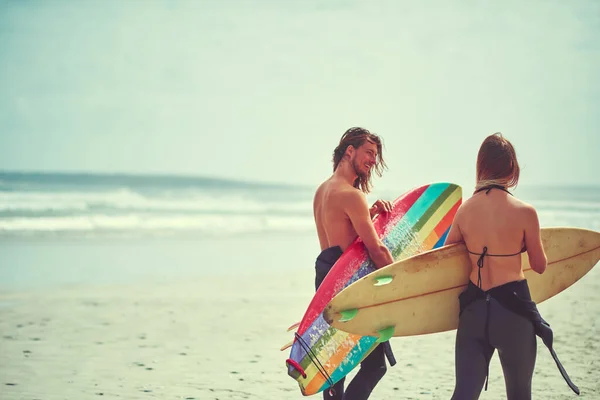 幸福是波浪形的 一对带着冲浪板在海滩上散步的年轻夫妇 — 图库照片