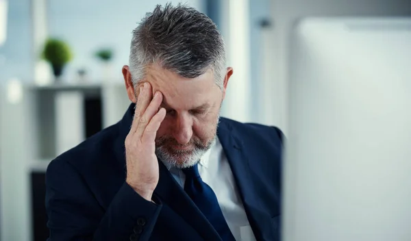 緊張が高まっています 現代のオフィスで仕事をしながら頭痛を経験する成熟したビジネスマンは — ストック写真