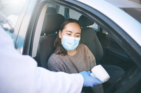 保持警觉 保持安全 一位戴着口罩的年轻女子坐在车里接受医生的体温检查 — 图库照片
