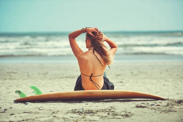 夏の日にするのが一番です ビーチでサーフィンをしている美しい若い女性が — ストック写真