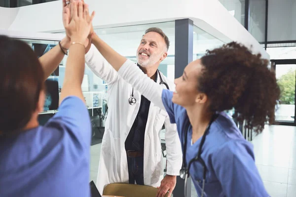 让我们好好发挥我们的作用 一队医生在医院里挤在一起手牵手 — 图库照片