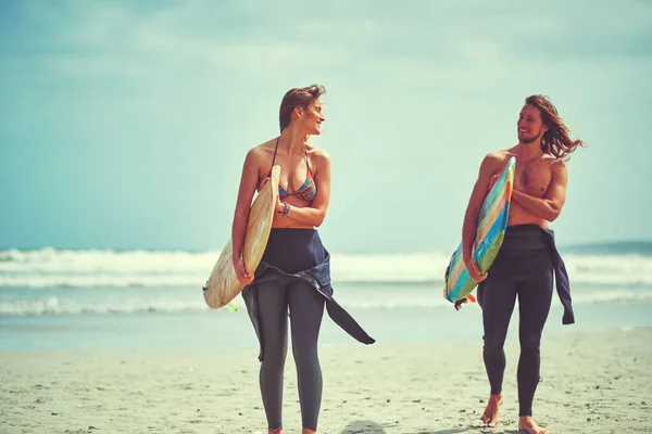 そして 私たちが恋に落ちたとき 若いカップルがサーフボードを持ってビーチを歩いていて — ストック写真
