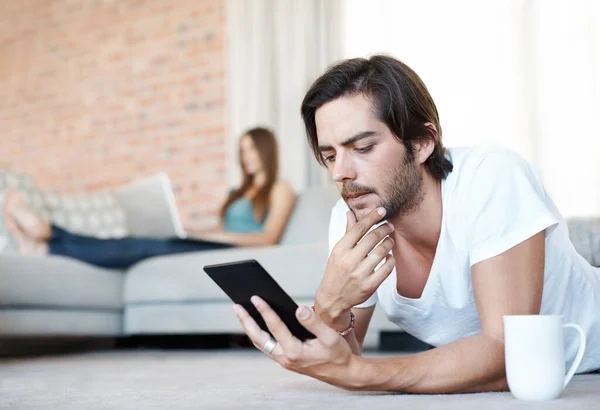 Hmm Interesujące Atrakcyjny Młodzieniec Czytający Domu Tablet — Zdjęcie stockowe