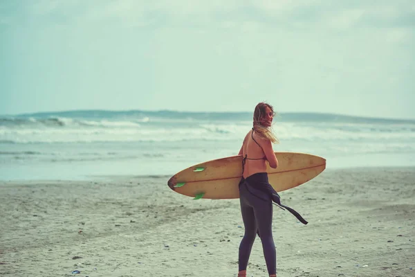 サーフィンの振動 ビーチでサーフィンをしている美しい若い女性が — ストック写真