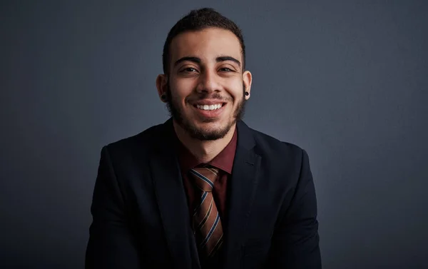 stock image Hes an equal mix of confidence and positivity. Studio portrait of a stylish young businessman against a gray background