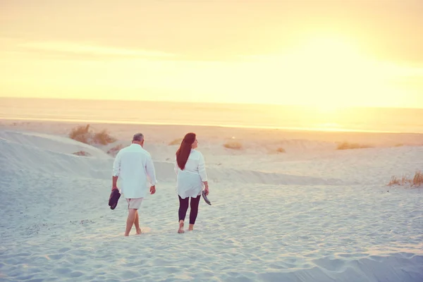 ゆっくりとビーチに沿って散歩 成熟したカップルはビーチでリラックスした散歩をし — ストック写真