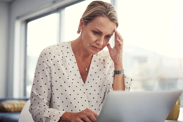 Stock image The system needs upgrading. a mature businesswoman working from her home office