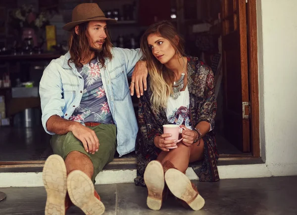 stock image Wild hearts cant be broken. an affectionate young couple sitting in the doorway of a roadside shop