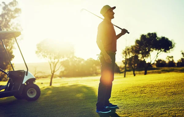 緑の上にいることほど気分がいいものはない ゴルフをしている若い男が — ストック写真