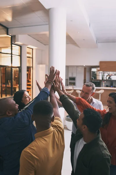 stock image Team spirit is knowing and living the belief that what a group of people can accomplish. a team high fiving each other in a office