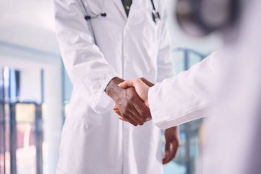 İyi bir doktor her hastane için değerlidir. İki tanınmayan doktor hastanede el sıkışıyor.