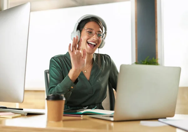ヘッドフォンと挨拶でビデオ通話でバーチャルミーティング ビジネス女性の笑顔と波 ラップトップ オフィスでコンピュータとデジタル通信を持つ企業でのウェビナーでの作業と従業員 — ストック写真