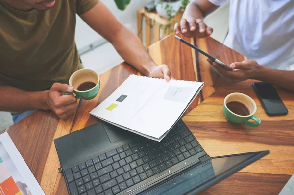 Stock image Technology will never replace vital paperwork. two unrecognizable friends sitting together and going through paperwork in a coffeeshop