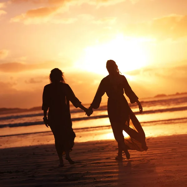 あなたの道を照らす人々と自分自身を囲みます 2人の若い女性が日没時にビーチで過ごし — ストック写真