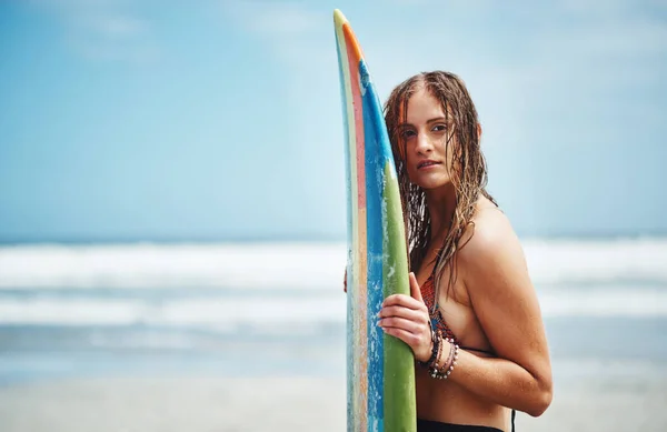 波を打ち砕いてやる サーフボードのあるビーチに立つ魅力的な若い女性は — ストック写真