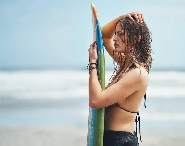 完璧な波を待ってる サーフボードのあるビーチに立つ魅力的な若い女性は — ストック写真