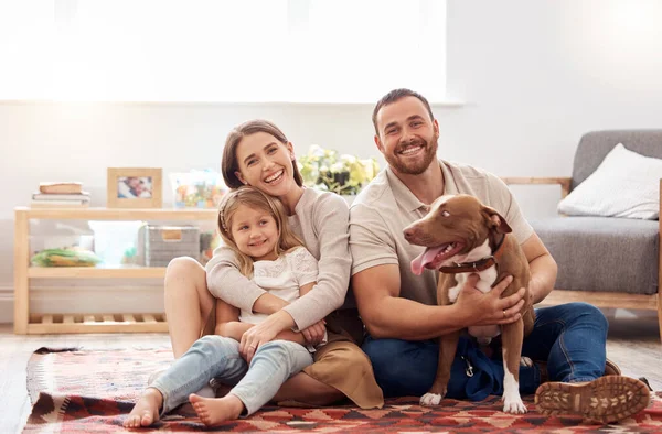 stock image Mom, dad and portrait of kid with dog in living room for quality time, love and care together at home. Mother, father and happy family with child, pet pitbull and relax for happiness on carpet floor.