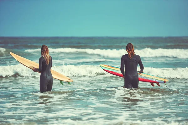 彼らの生き方を一緒にサーフィン ビーチでサーフィンをしている若いカップルが — ストック写真