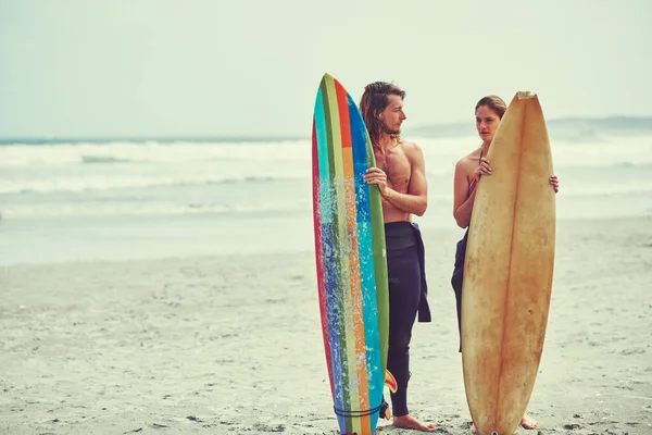 あなたと共にあるために最も荒波に乗る サーフィンで一日を過ごしている若いカップルが — ストック写真