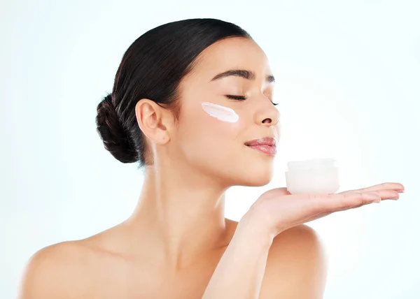 Skincare, face cream and woman with container in studio isolated on a white background. Lotion, dermatology product and female model with sunscreen, beauty cosmetics or smell healthy skin moisturizer.