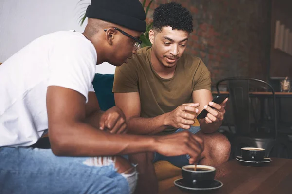 これは私が話していたデートアプリです 男たちは喫茶店に座って携帯電話で何かを話し合い — ストック写真