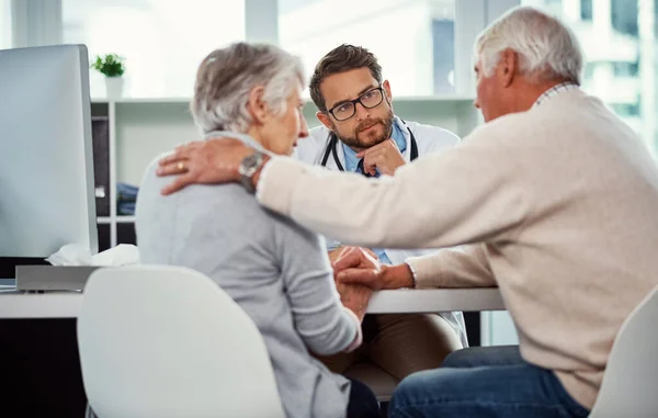 stock image His duty and commitment is to care. a senior man consoling his wife during a consultation with a doctor in a clinic