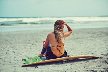 Sörf. Bütün gün. - Her gün. Genç ve güzel bir kadın sahilde sörf yapmaya gidiyor.