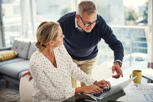 stock image They share the budgeting responsibilities. a mature couple using a laptop while going through paperwork at home