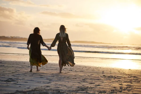 人生の旅を楽しむだけです 2人の若い女性が日没時にビーチで過ごし — ストック写真