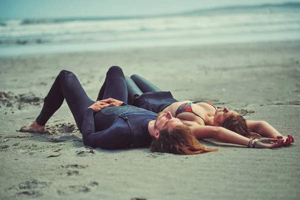 在冲浪后打盹 一对在海滩冲浪后放松的年轻夫妇 — 图库照片