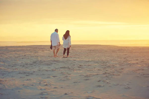 ビーチで長い散歩をお楽しみください ビーチを歩く愛情のある成熟したカップルのレビューショット — ストック写真
