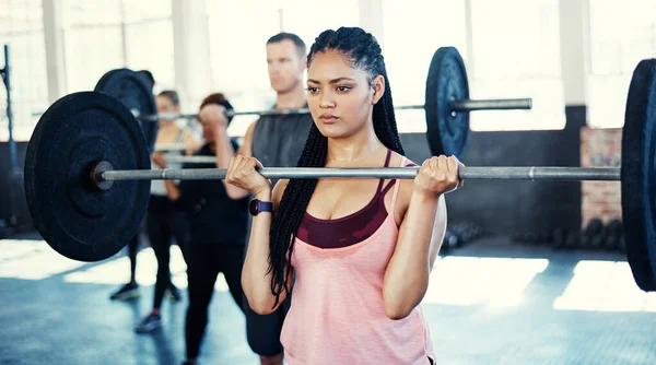 开始力量训练 在健身房的时候 一个女人带着一个杠铃在锻炼 — 图库照片