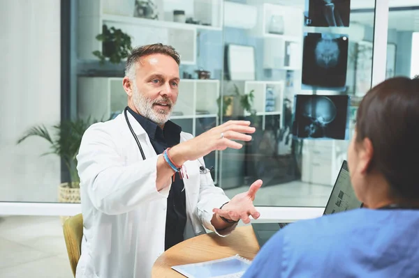 stock image Sharing his insights from years of service. a mature doctor having a discussion with a colleague in a hospital