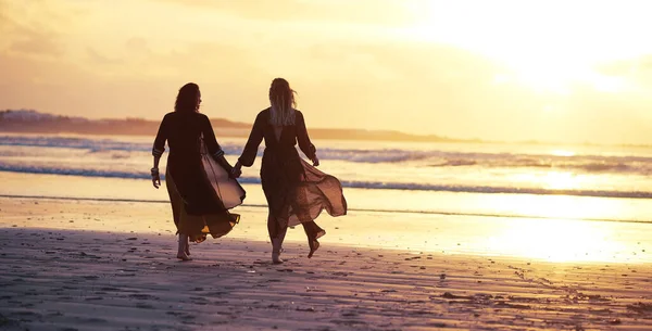 あなたの翼は既にそう先に行き 飛ぶ存在する 2人の若い女性が日没時にビーチで過ごし — ストック写真