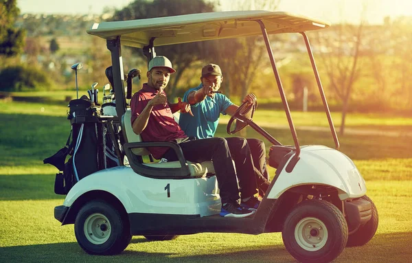 没有什么比和朋友打高尔夫更好的事了 两个高尔夫球手骑在高尔夫球场的推车上 — 图库照片