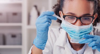 Kadın, bilim adamı petri kabı ve yüz maskesi fütüristik araştırma ve virüs verilerine odaklı. Bilim, Afrikalı kadın ve genç çalışanlar kimya testi analizi için laboratuvarda çalışıyorlar..