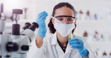 Bitkisel bitki ilaçları, laboratuvar araştırmaları ve deney tüpüyle çalışan bir kadın bilim adamı. Tıbbi ve analizler için laboratuvar, çalışma ve kimya maskeyle botanik analiz yapıyor..