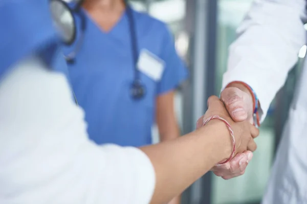 我不会让你失望的一个无法辨认的护士站在诊所里和医生握手 — 图库照片