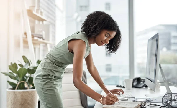 コンピュータ スケジュールやビジネスの女性は 企業のスタートアップで彼女の机やテーブルのそばに書いて立っている インターネット オンラインおよびプロの女性従業員 ノートブック内のアシスタントやプランナーの計画 — ストック写真