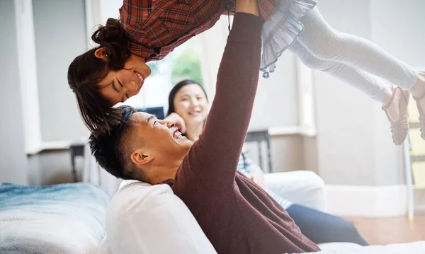 stock image Theres nothing more important than family. a handsome young man playing with his daughter on the sofa at home