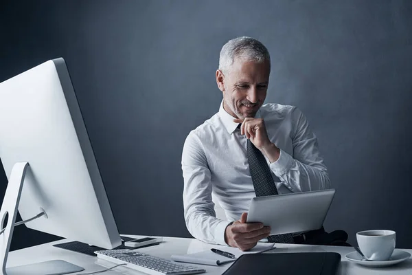 stock image Thats impressive...a mature businessman working on his tablet